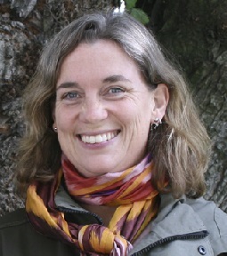 Kvinna med brunt hår till axlarna och färgglad halsduk. Foto